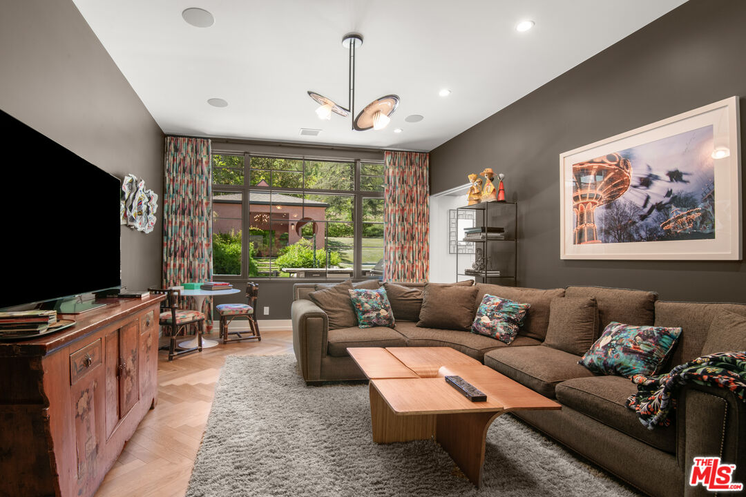 16001 Woodvale Road Encino, CA 91436 - Photo 15 of 49 a living room with furniture a flat screen tv and a large window