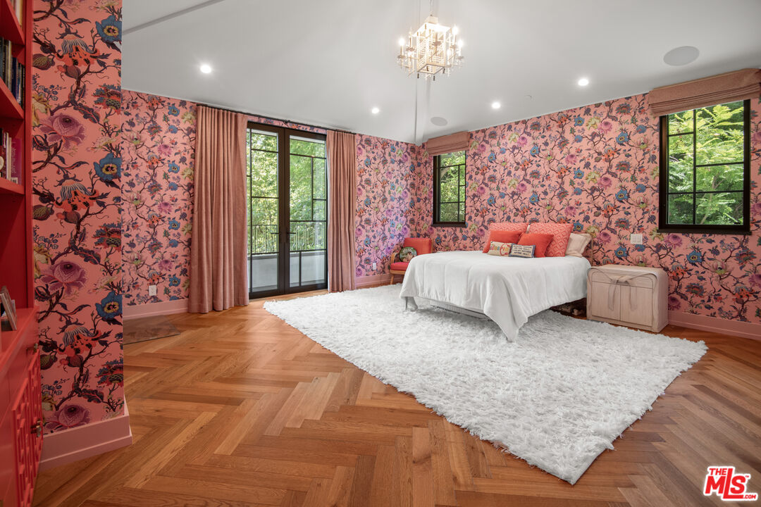 16001 Woodvale Road Encino, CA 91436 - Photo 24 of 49 a spacious bedroom with a large bed and a chandelier