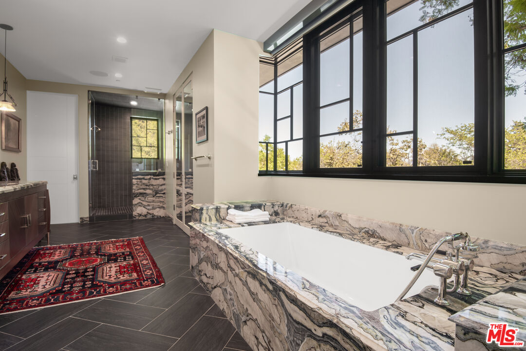 16001 Woodvale Road Encino, CA 91436 - Photo 30 of 49 a bathroom with a double vanity sink and a bathtub