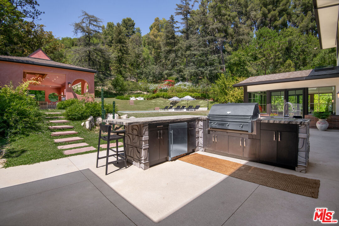 16001 Woodvale Road Encino, CA 91436 - Photo 32 of 49 a view of a patio with table and chairs potted plants with wooden fence