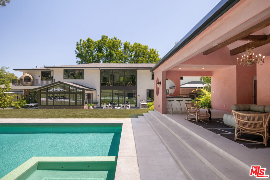 16001 Woodvale Road Encino, CA 91436 - Photo 33 of 49 a front view of a house with a garden and patio