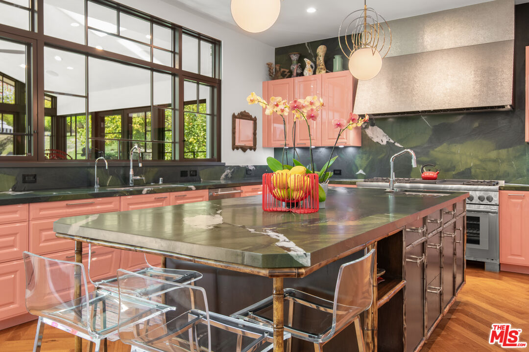 16001 Woodvale Road Encino, CA 91436 - Photo 10 of 49 a kitchen with stainless steel appliances granite countertop a sink a stove and a wooden cabinets