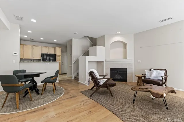 a living room with furniture a fireplace and kitchen view