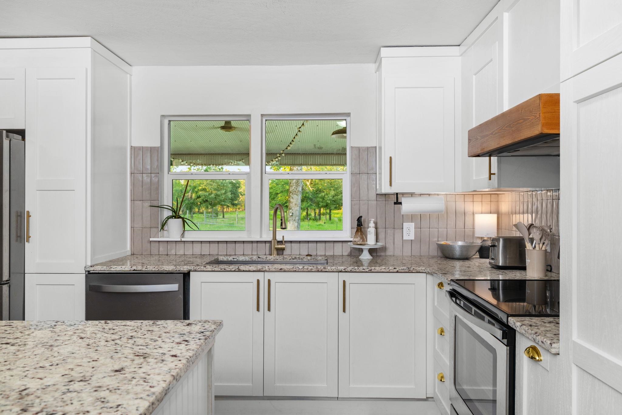 66 County Road 511 Corinth, MS 38834 - Photo 11 of 40 Modern kitchen featuring white shaker cabinetry and light-colored granite countertops
