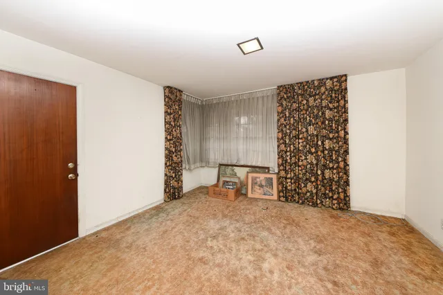a view of an empty room with a fireplace and a window