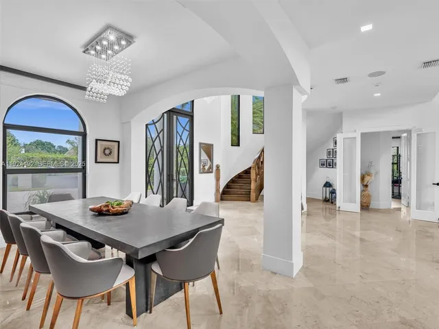 a kitchen with stainless steel appliances granite countertop table chairs sink and cabinets