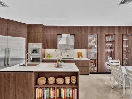 a backyard of a house with plants and large tree