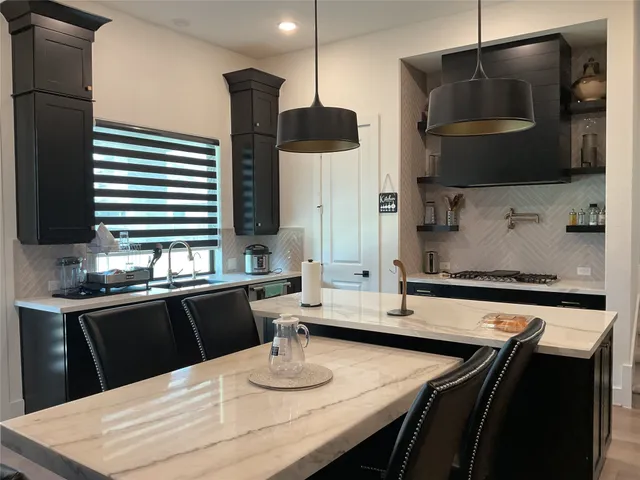 a kitchen with a sink a counter top space cabinets and stainless steel appliances