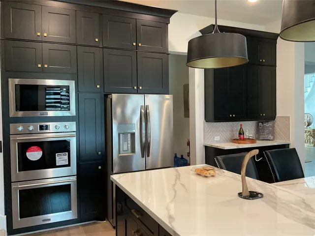 a kitchen with stainless steel appliances a stove a refrigerator and a oven