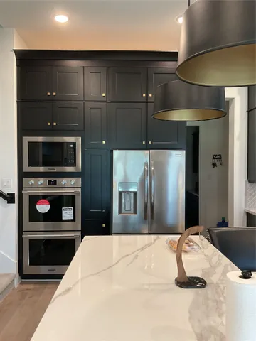 a kitchen with a refrigerator and a stove top oven