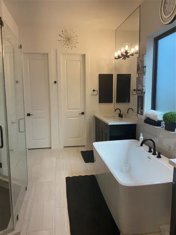 a bathroom with a tub sink and mirror
