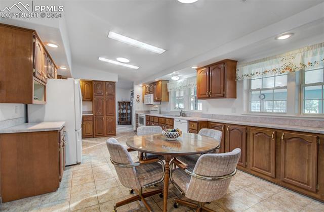 12825 Garrett Road Peyton, CO 80831 - Photo 21 of 47 Kitchen with light tile patterned floors, sink, and white appliances