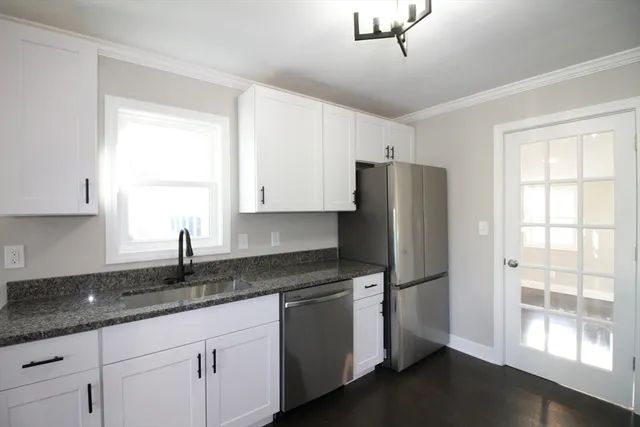a kitchen with granite countertop a refrigerator and a sink