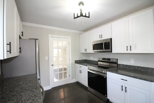 a kitchen with stainless steel appliances granite countertop a stove a sink and a microwave