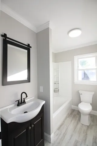 a bathroom with a toilet sink and mirror