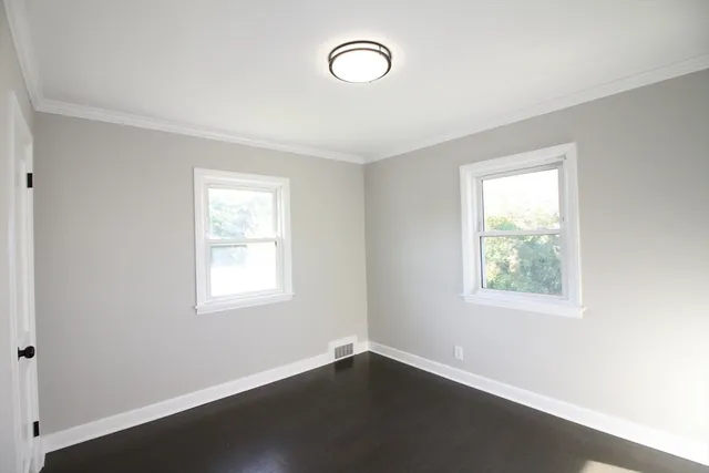 an empty room with a window and wooden floor