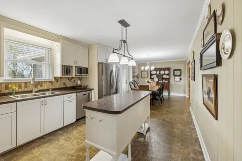 a kitchen with stainless steel appliances granite countertop a sink a stove and refrigerator
