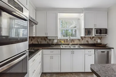 a kitchen with granite countertop a sink and a stove