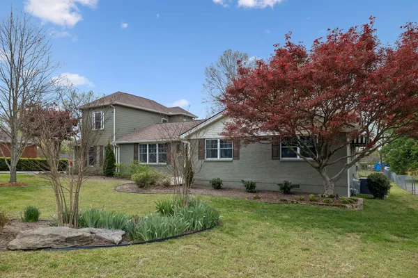a view of a house with yard and a garden