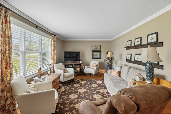 a dining room with furniture a chandelier and kitchen view