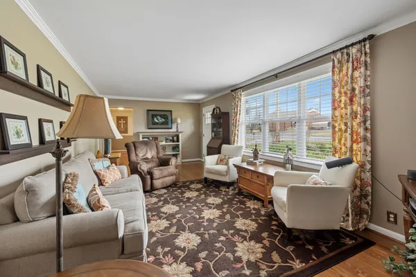 a dining room with furniture a chandelier and wooden floor