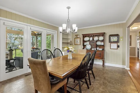a dining room with furniture a chandelier and window
