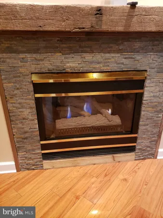an empty room with wooden floor fire place and windows