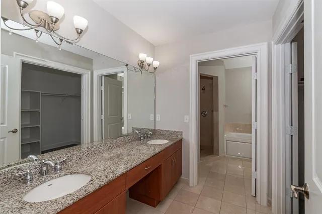 a bathroom with a granite countertop sink a light fixture and a mirror