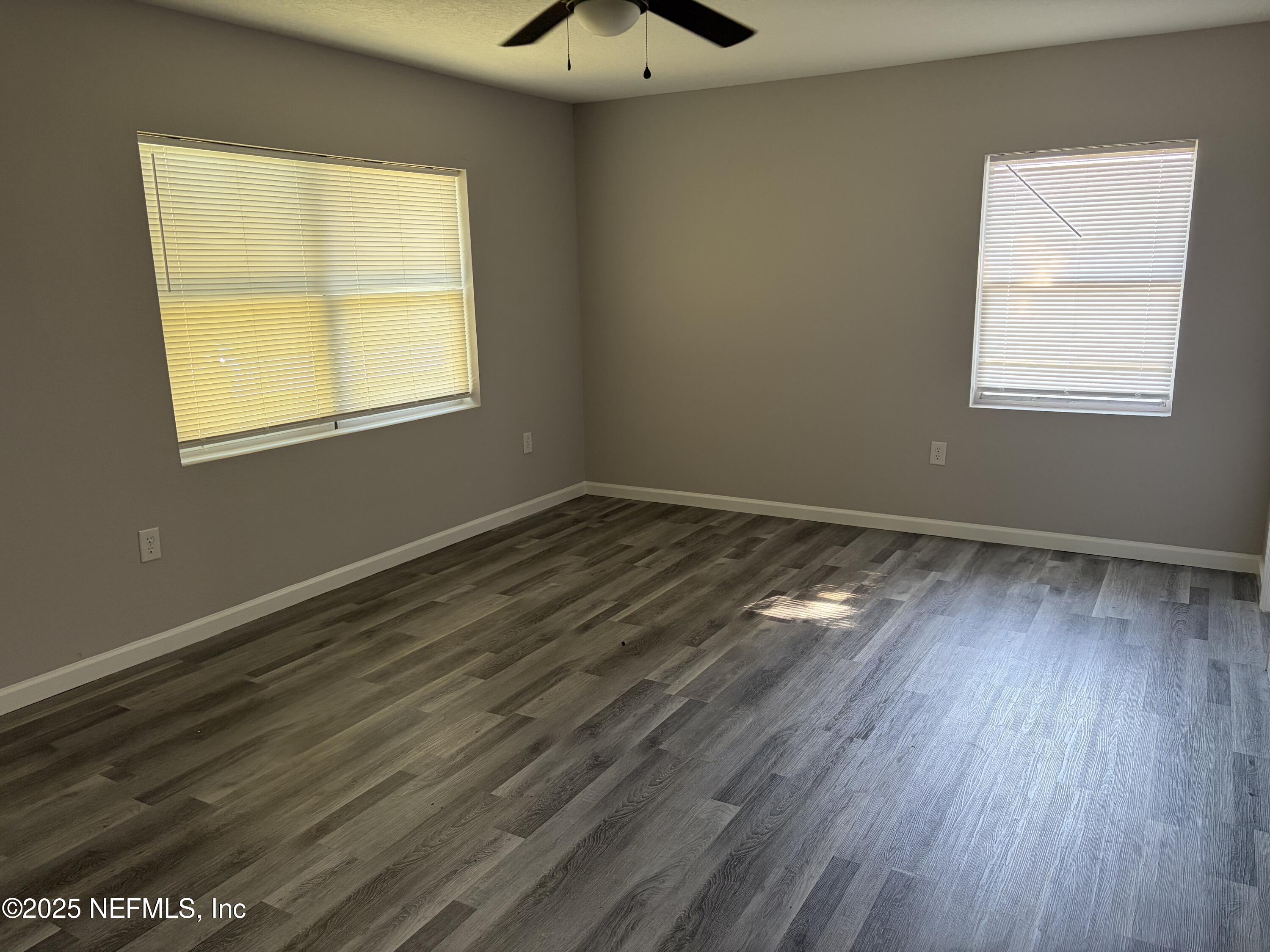 4444 Rainer Road Jacksonville, FL 32210 - Photo 13 of 19 a view of an empty room with wooden floor and a window