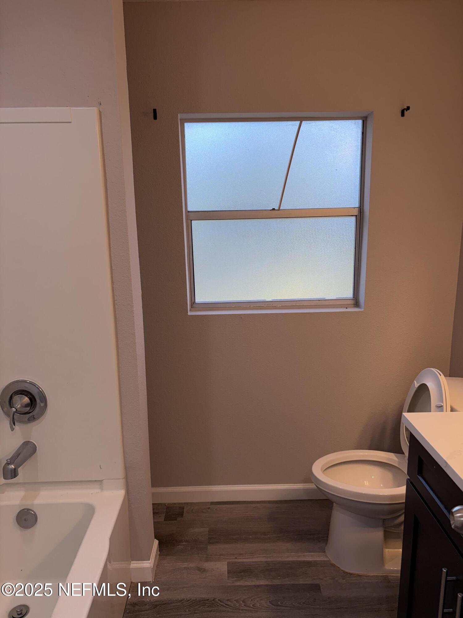 4444 Rainer Road Jacksonville, FL 32210 - Photo 17 of 19 a bathroom with a toilet a sink and mirror