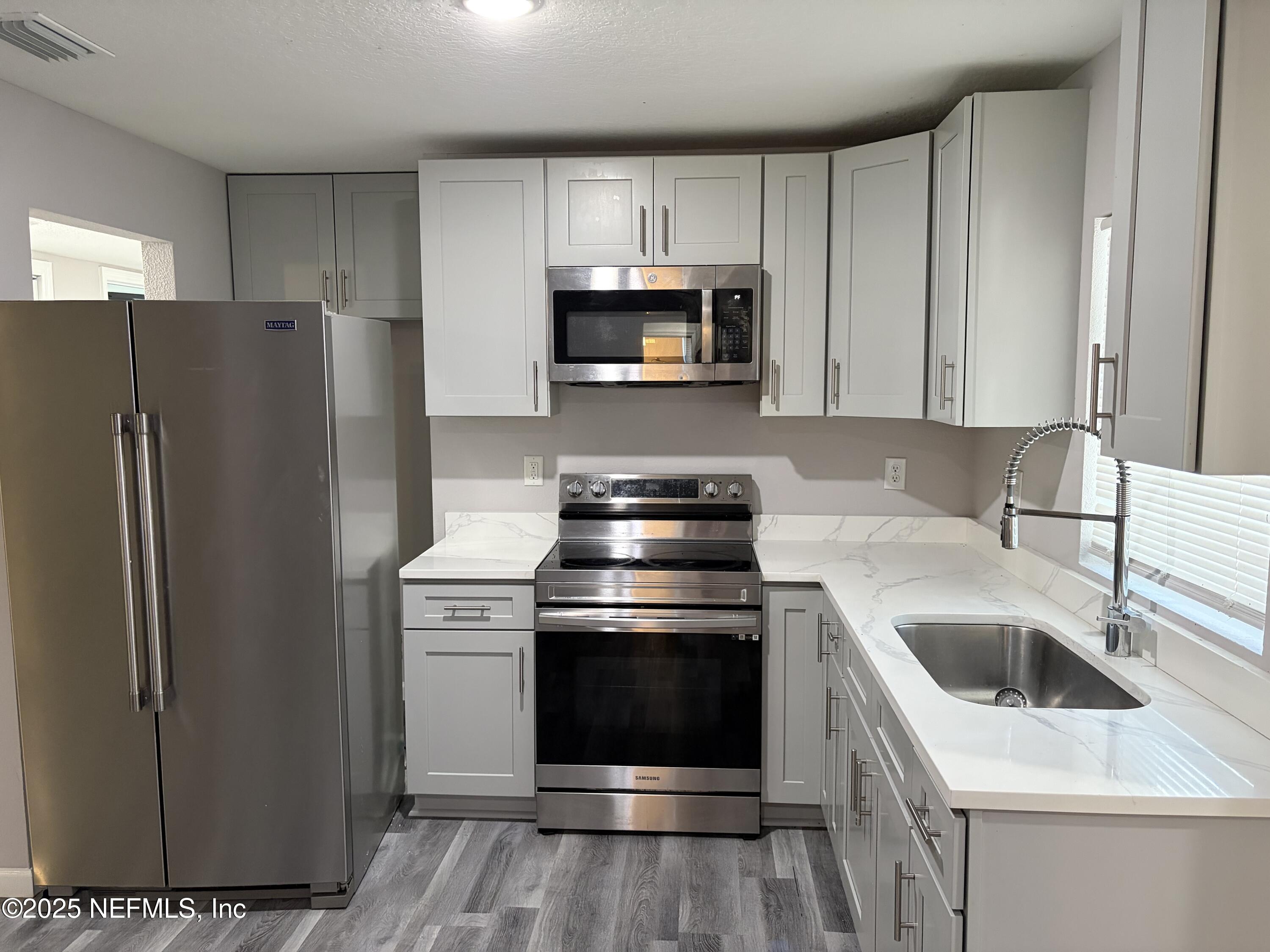 4444 Rainer Road Jacksonville, FL 32210 - Photo 5 of 19 a kitchen with a stove and a microwave
