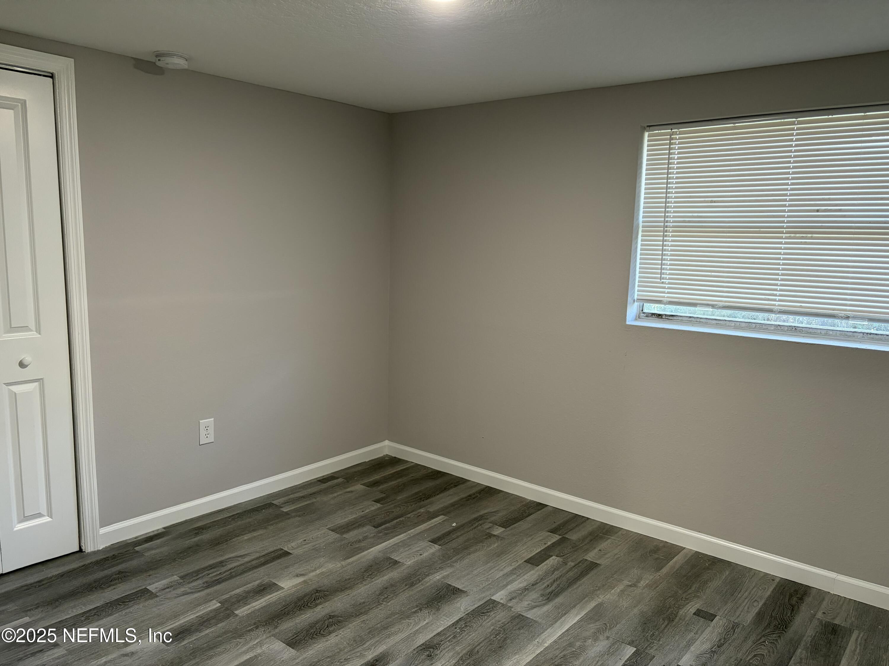 4444 Rainer Road Jacksonville, FL 32210 - Photo 8 of 19 an empty room with wooden floor and windows