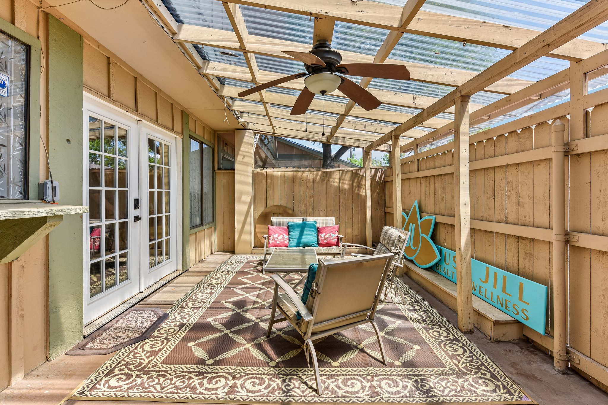 9610 Covey Ridge Lane Austin, TX 78758 - Photo 19 of 22 Covered patio featuring a translucent panel roof, ceiling fan, wood-paneled walls, and French doors