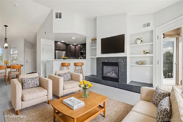 a living room with furniture a flat screen tv and a fireplace