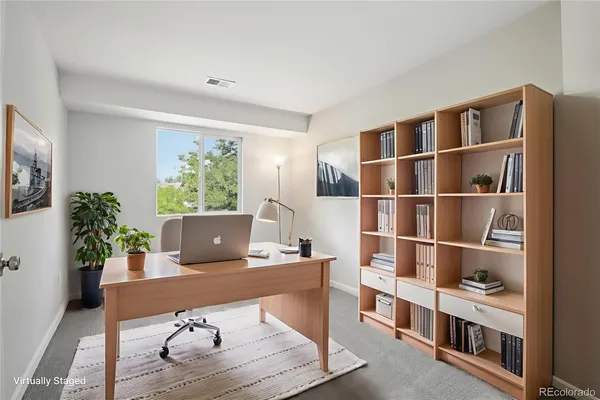 a living room with furniture and a bookshelf with wooden floor