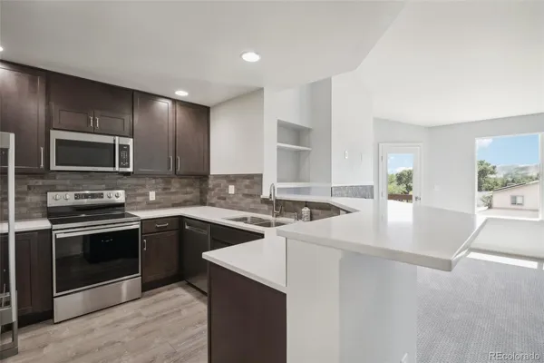 a kitchen with stainless steel appliances granite countertop a sink and stove top oven
