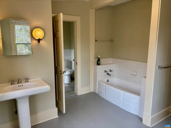 a bathroom with a bathtub a sink and a mirror