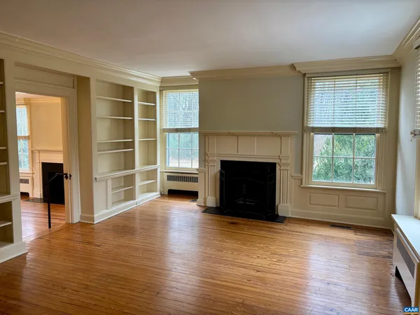 an empty room with windows and a fireplace
