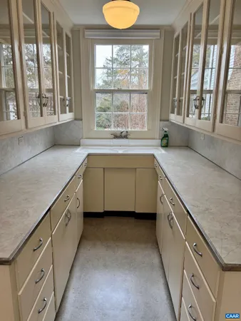 a utility room with granite countertop a sink and a window