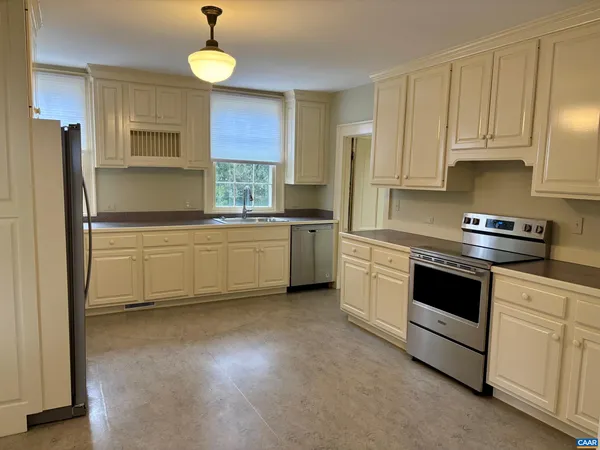 a kitchen with stainless steel appliances white cabinets and a refrigerator