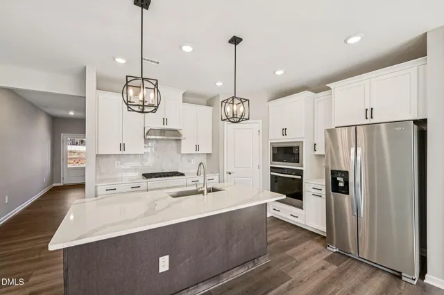 a very nice looking kitchen with center island stainless steel appliances and cabinets