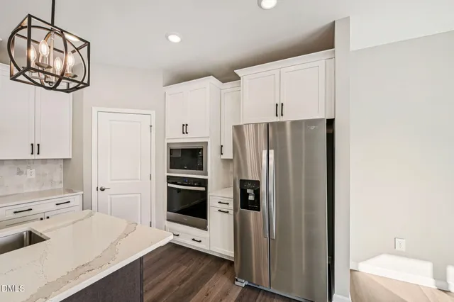 a kitchen with stainless steel appliances a refrigerator sink and cabinets