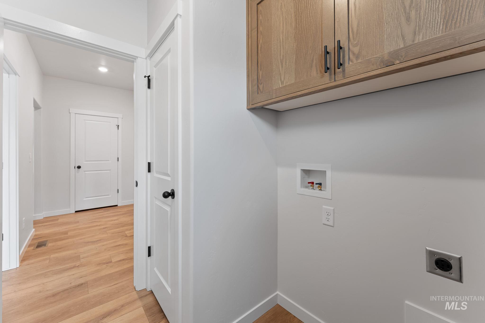 2220 Great Basin Way Burley, ID 83318 - Photo 25 of 39 Laundry room featuring light wood-style floors, hookup for a washing machine, electric dryer hookup, recessed lighting, and cabinet space