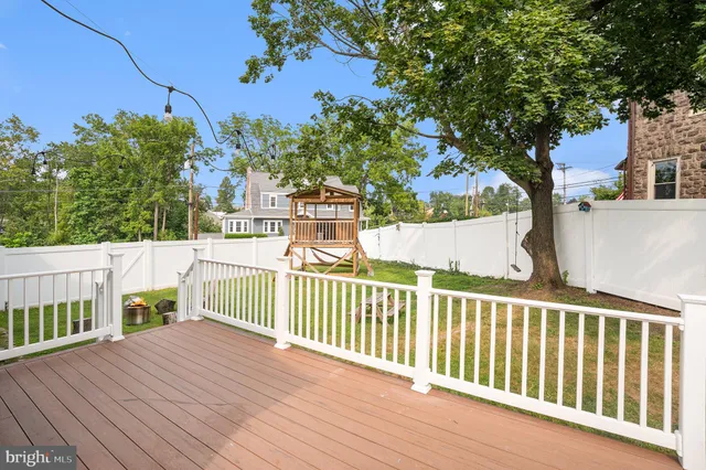 a view of a fence and trees from a balcony
