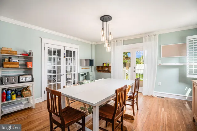 a view of a dining room with furniture wooden floor and a book shelf