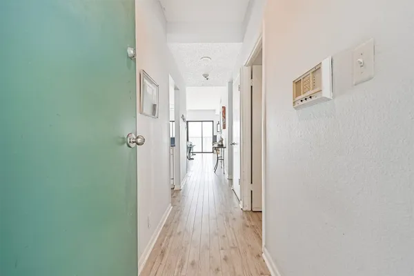 a view of a hallway with wooden floor and closet