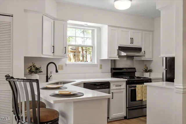 a kitchen with granite countertop a sink stove and cabinets