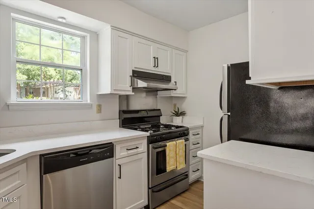 a kitchen with stainless steel appliances a stove microwave and a refrigerator