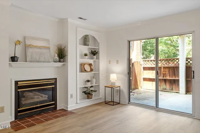 a view of livingroom with furniture a fireplace and windows