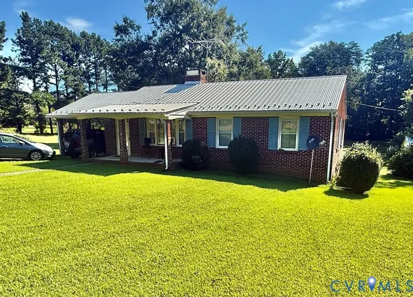 a view of a house with a yard and potted plants